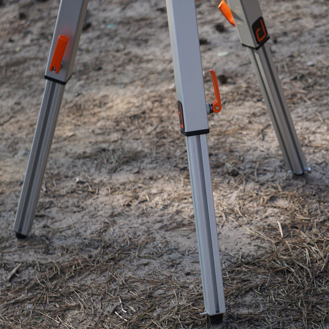Three metal stakes with orange accents on a sandy surface